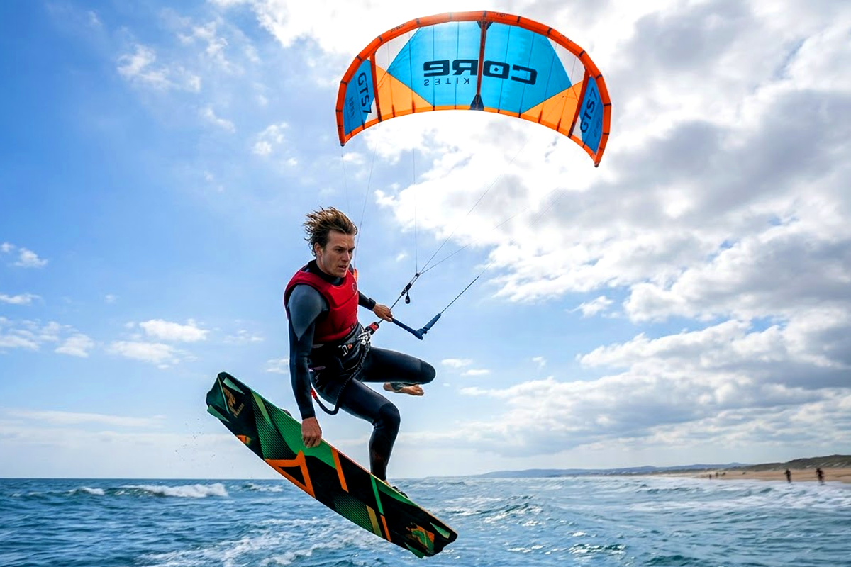 Kitesurfer que impulsa el aire grande con la sobrecabeza de cometa