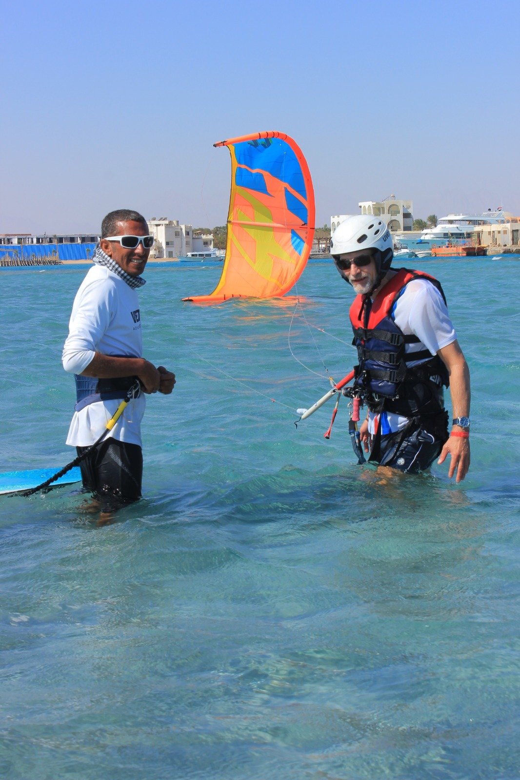 Masters Surf School Instructor ayudando a un principiante a lanzar una cometa en la playa en Hurghada.