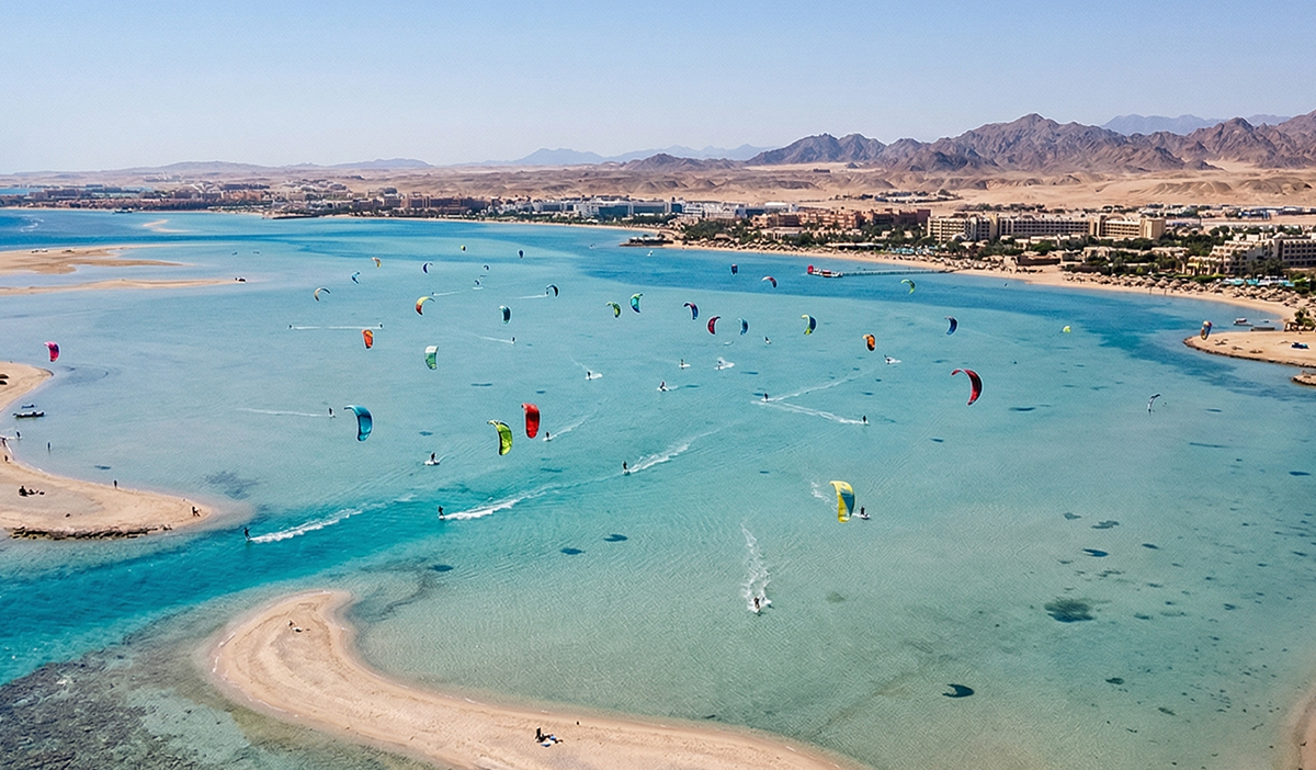 Un amplio drone de una enorme laguna de aguas llanas en Hurghada con coloridas cometas en el cielo