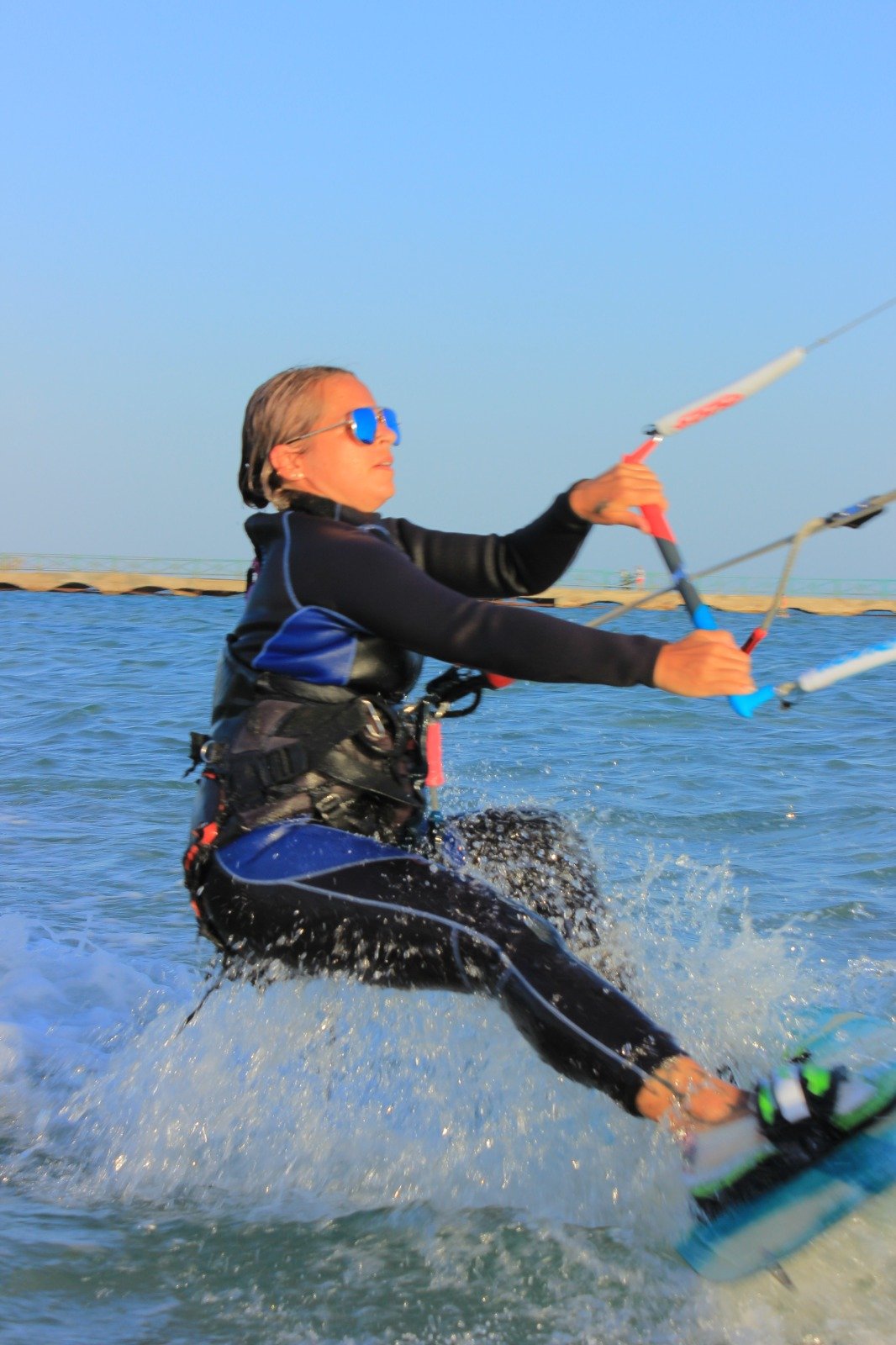 Beginner kitesurfer practicing body dragging in the shallow, flat water lagoon in Hurghada.