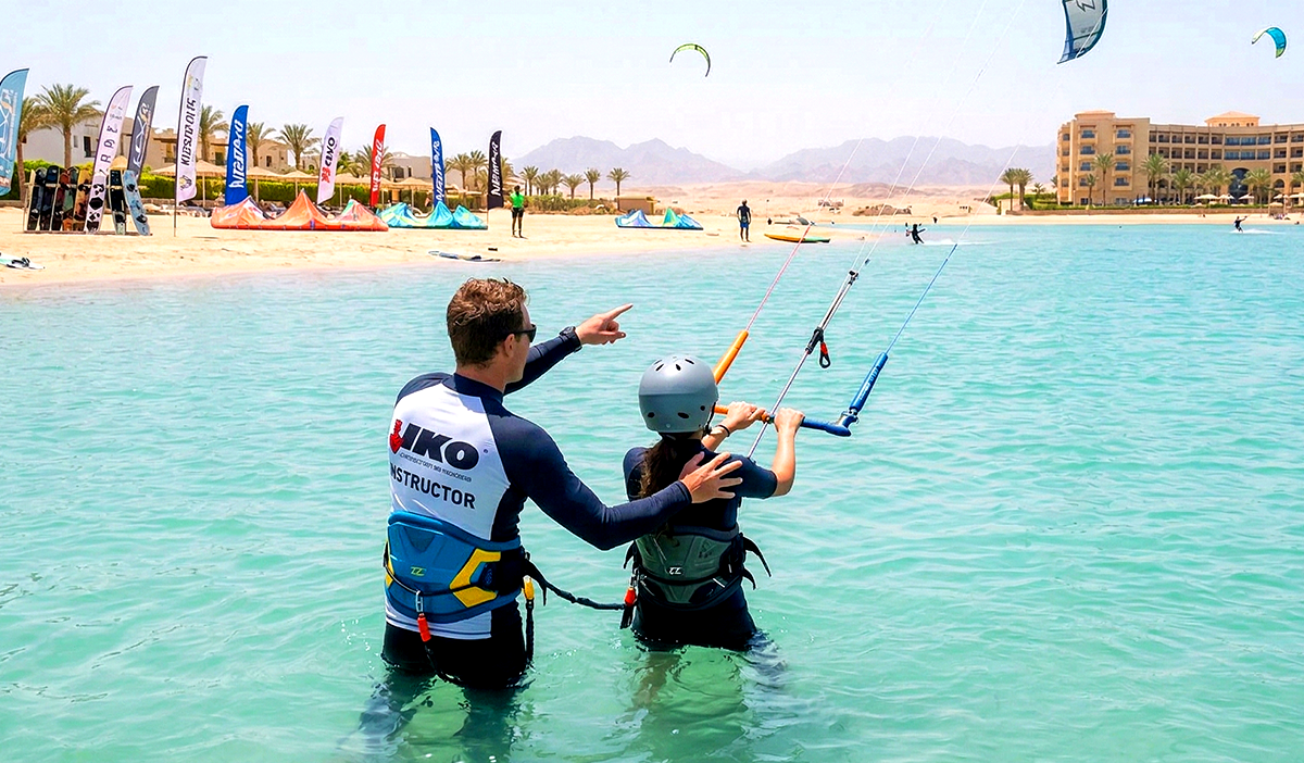 Сертифицированный инструктор IKO помогает студенту в воде по пояс в школе кайтсерфинга Хургады