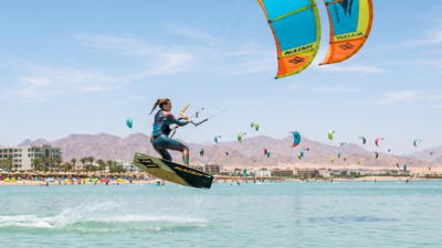 Kitesurfer jumping on flat water at Al Ahyaa Lagoon in Hurghada during peak summer season.