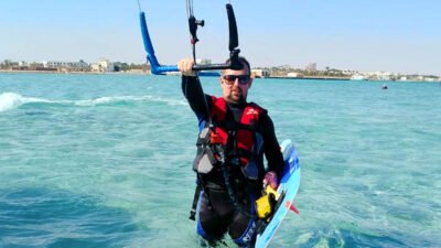 Kitesurfer montando una tabla de puntas gemelas sobre aguas claras en el Mar Rojo Egipto