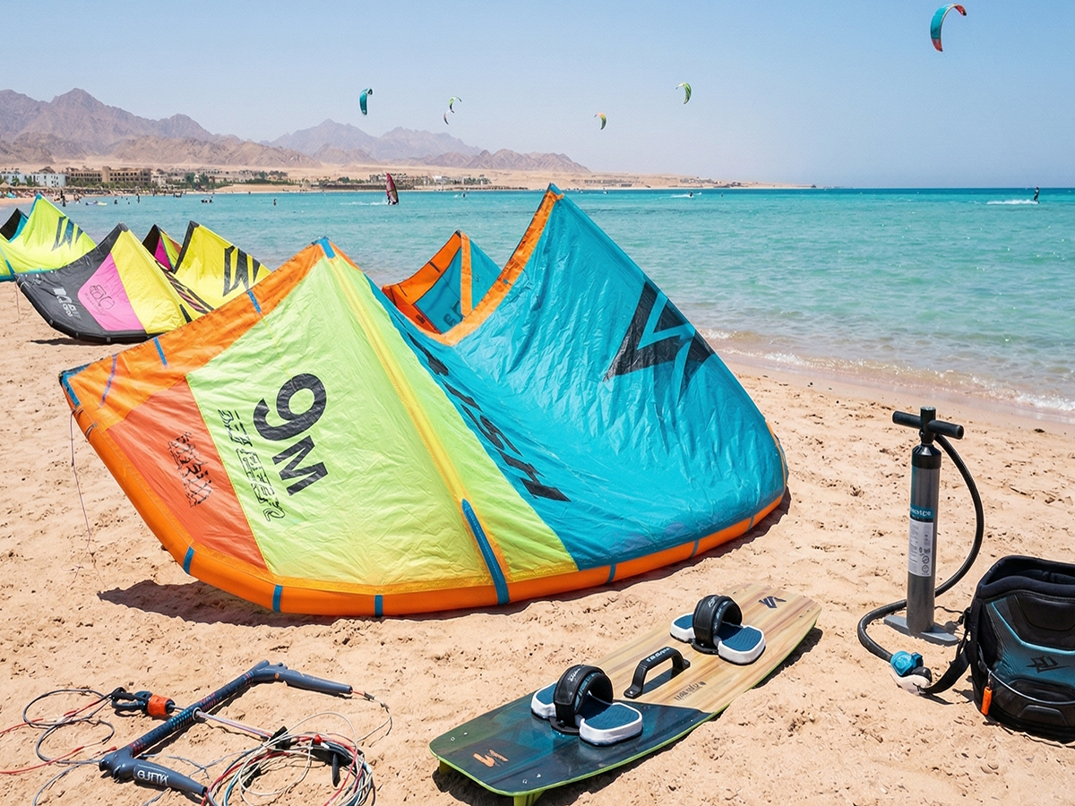 Kitesurfing gear laid out on a beach in Hurghada showing a 9m kite and a twintip board.