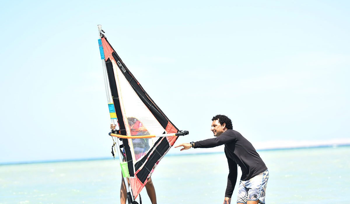 Beginner windsurfer practising in shallow waters of Hurghada Masters surf school Lagoon, Egypt