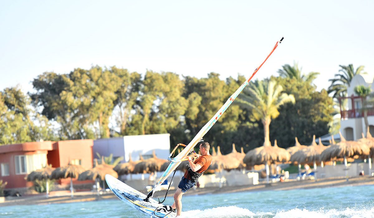 Técnica de auto-rescate: tabla de remo de windsurfista mientras está acostado boca abajo con vela equilibrada
