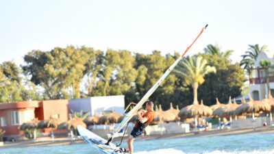 Técnica de auto-rescate: tabla de remo de windsurfista mientras está acostado boca abajo con vela equilibrada