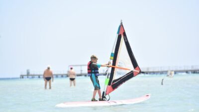 Windsurfer planeando a través de laguna poco profunda en Magawish, Hurghada Egipto