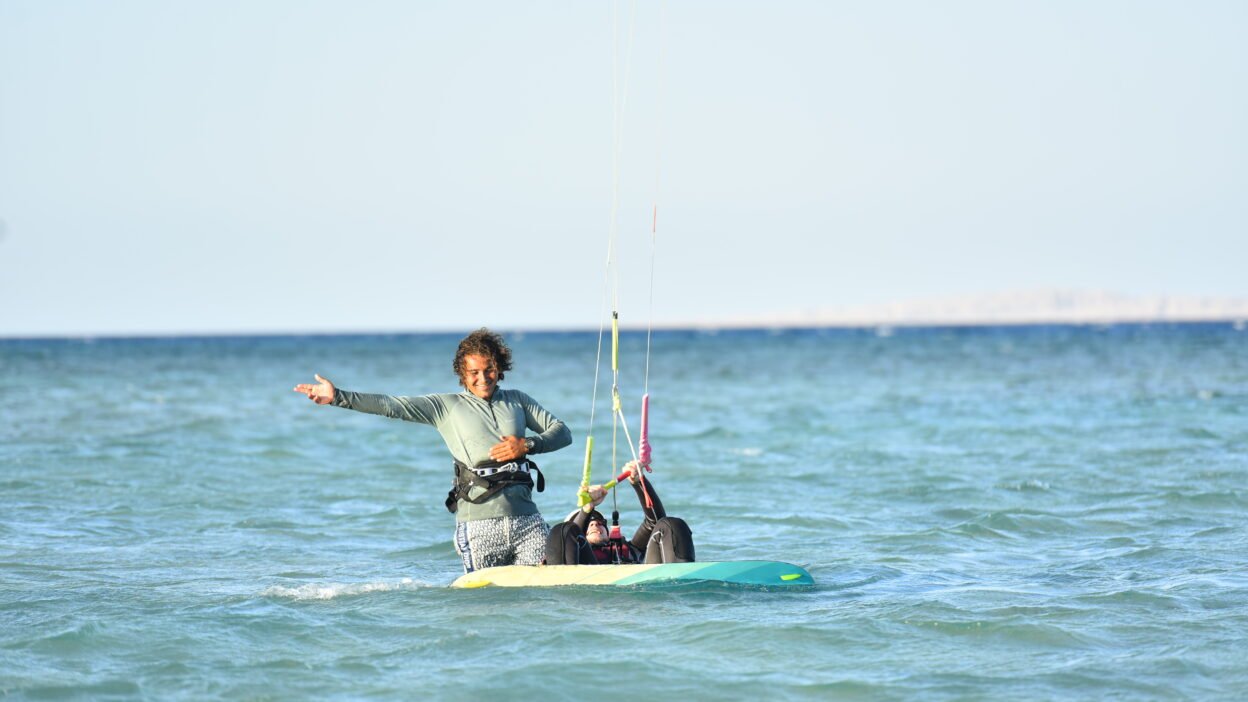 Masters Surf School instructor teaching a child kitesurfing in shallow Hurghada lagoon